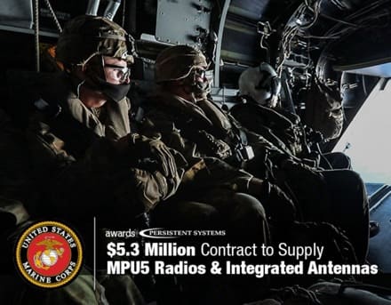 Three military personnel in flight gear sit in a cockpit; overlay text reads '$5.3 Million Contract to Supply MPU5 Radios & Integrated Antennas' with the U.S. Marine Corps emblem.